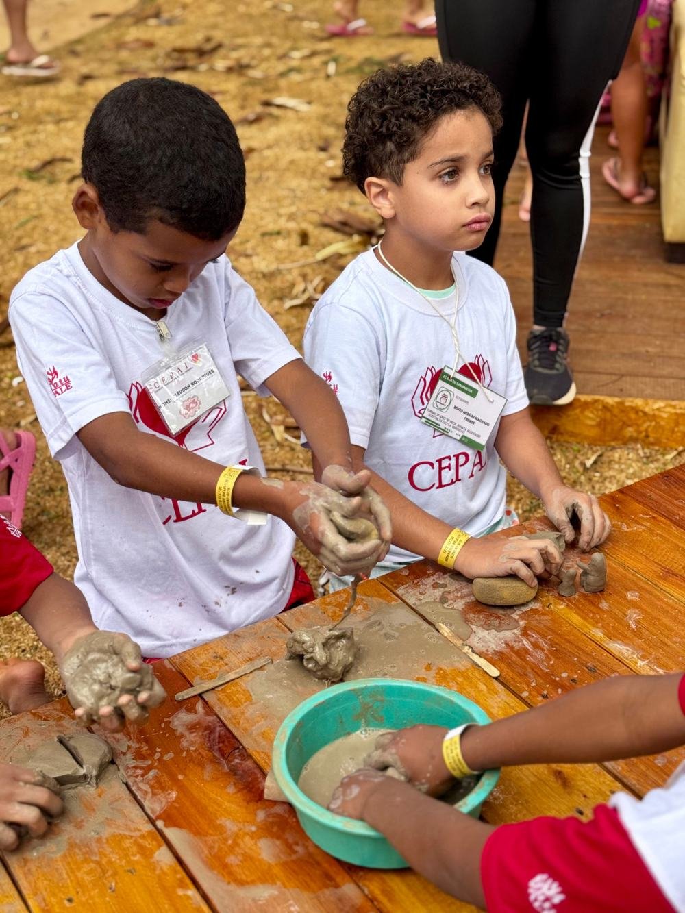 Crianças modelando argila no projeto Na Praia Social